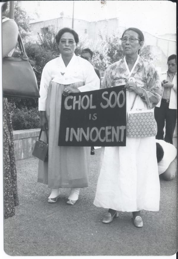 Two elderly Korean women wearing traditional dresses hold a sign that reads Chol Soo is innocent at a demonstration. Credit: Courtesy of Gail Whang.